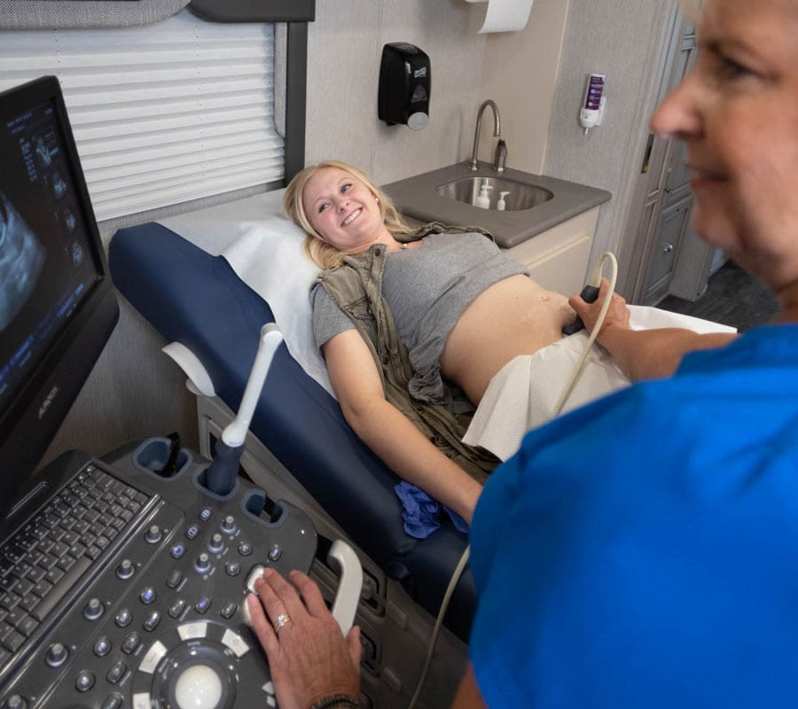 How We Do It A medical professional giving a woman an ultrasound at ICU Mobile