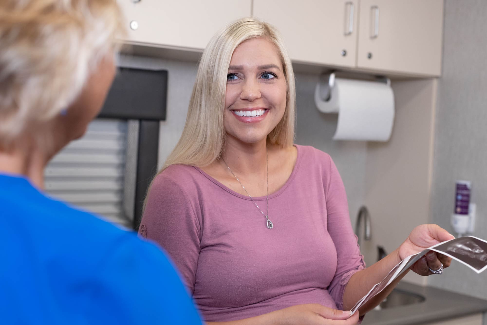 A woman looking at her ultrasound pictures provided by ICU Mobile