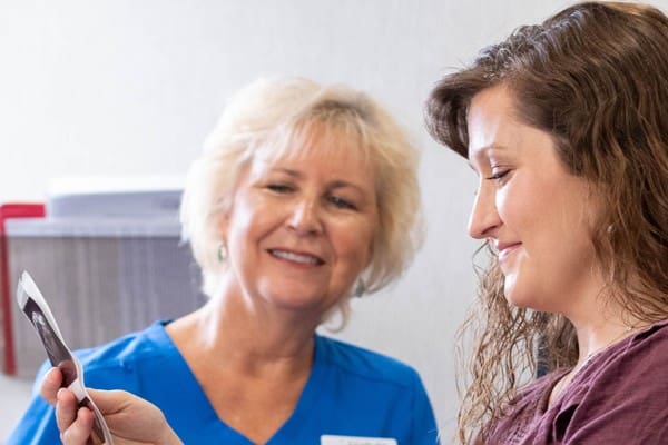 A woman looking at her ultrasound pictures provided by ICU Mobile