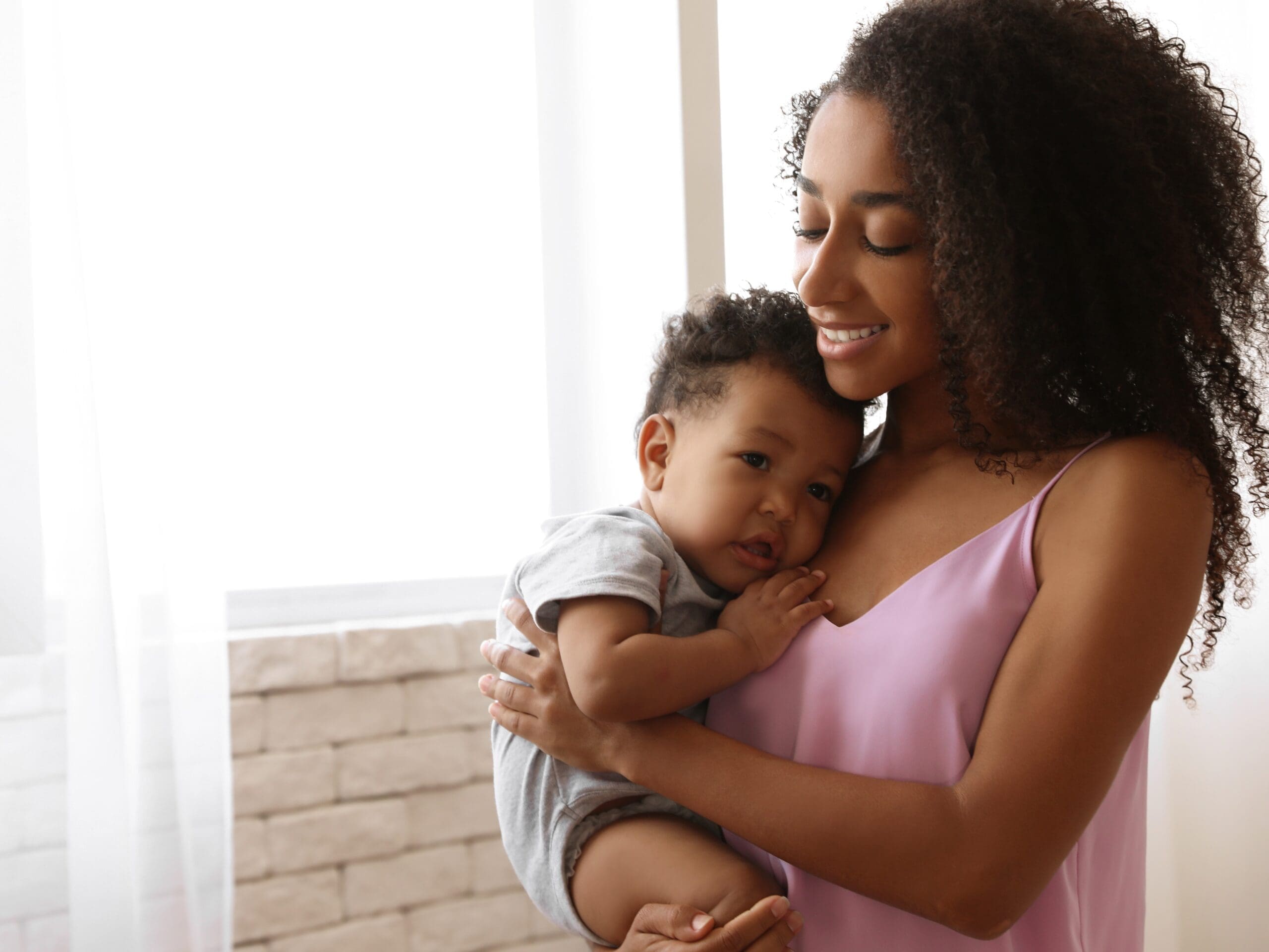 African-american Woman With Her Baby At Home. Happiness Of Motherhood A woman with her baby that was saved and delivered by ICU Mobile